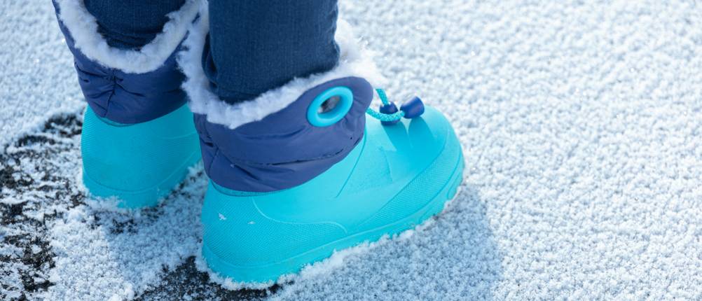 De belles Bottes d'hiver pour enfants bleues dans la neige
