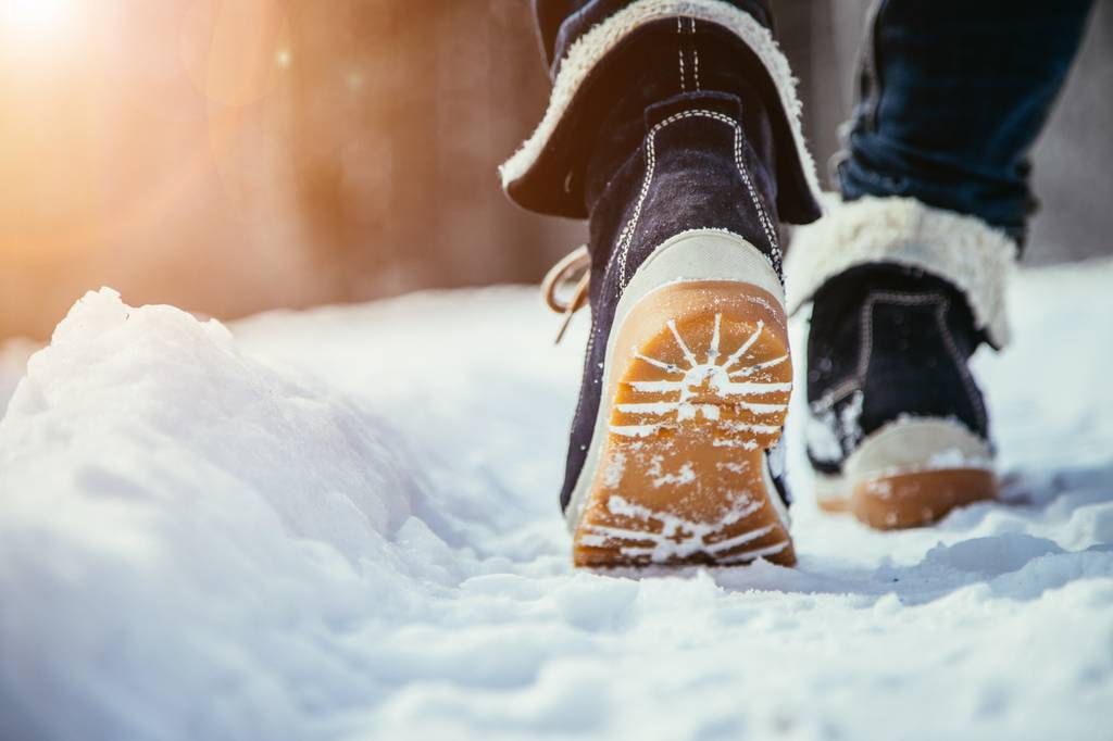 Un hommr marche sur la neige, équipé de bottes d'hiver pour homme